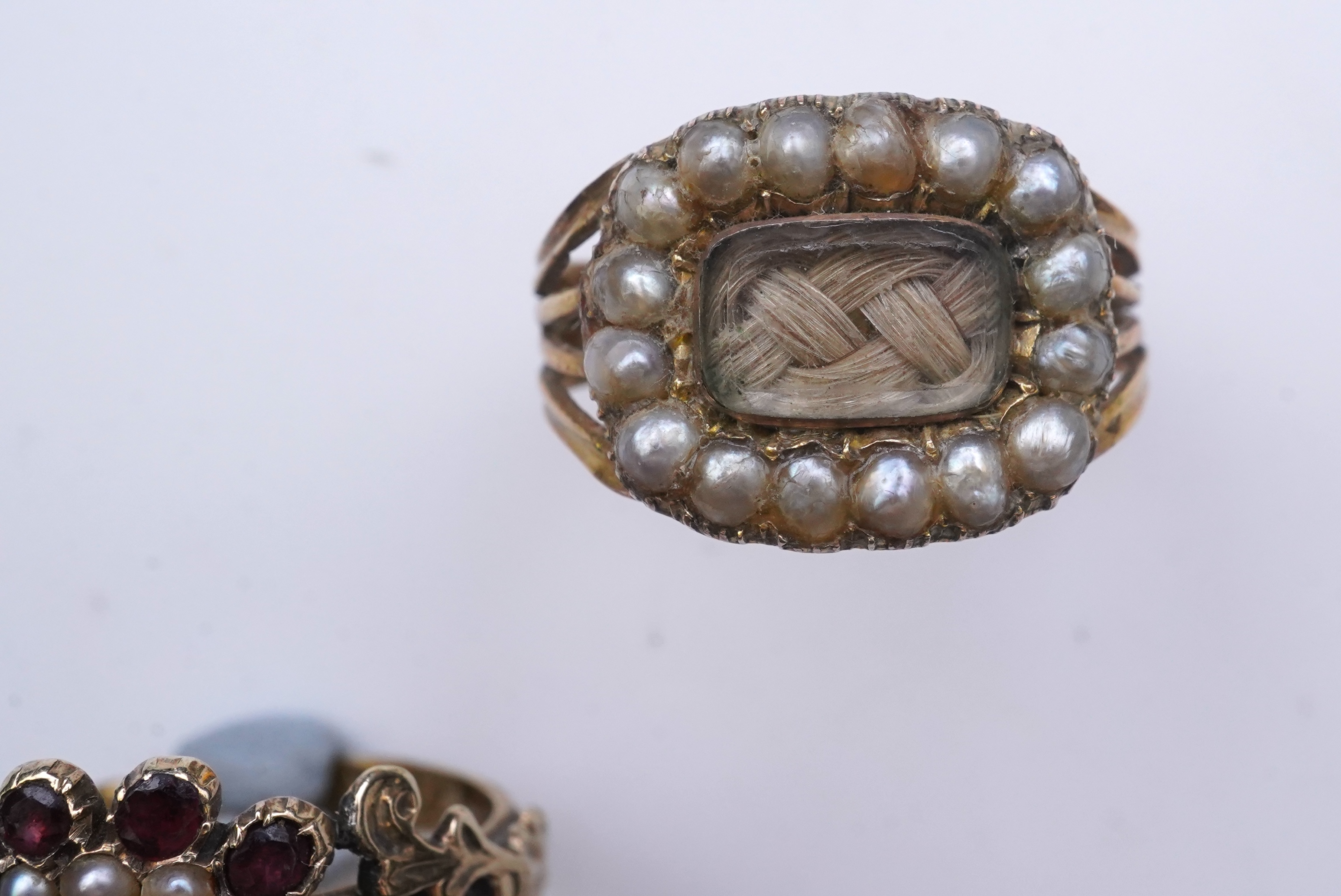 A George III seed pearl mourning ring and a garnet and seed pearl ring, mid 19th century